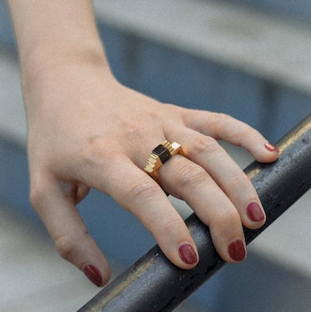 La bague Echelons associe le vermeil à un cube d’onyx noir dans un anneau carré inspiré de l’architecture moderne. Bijou porté.