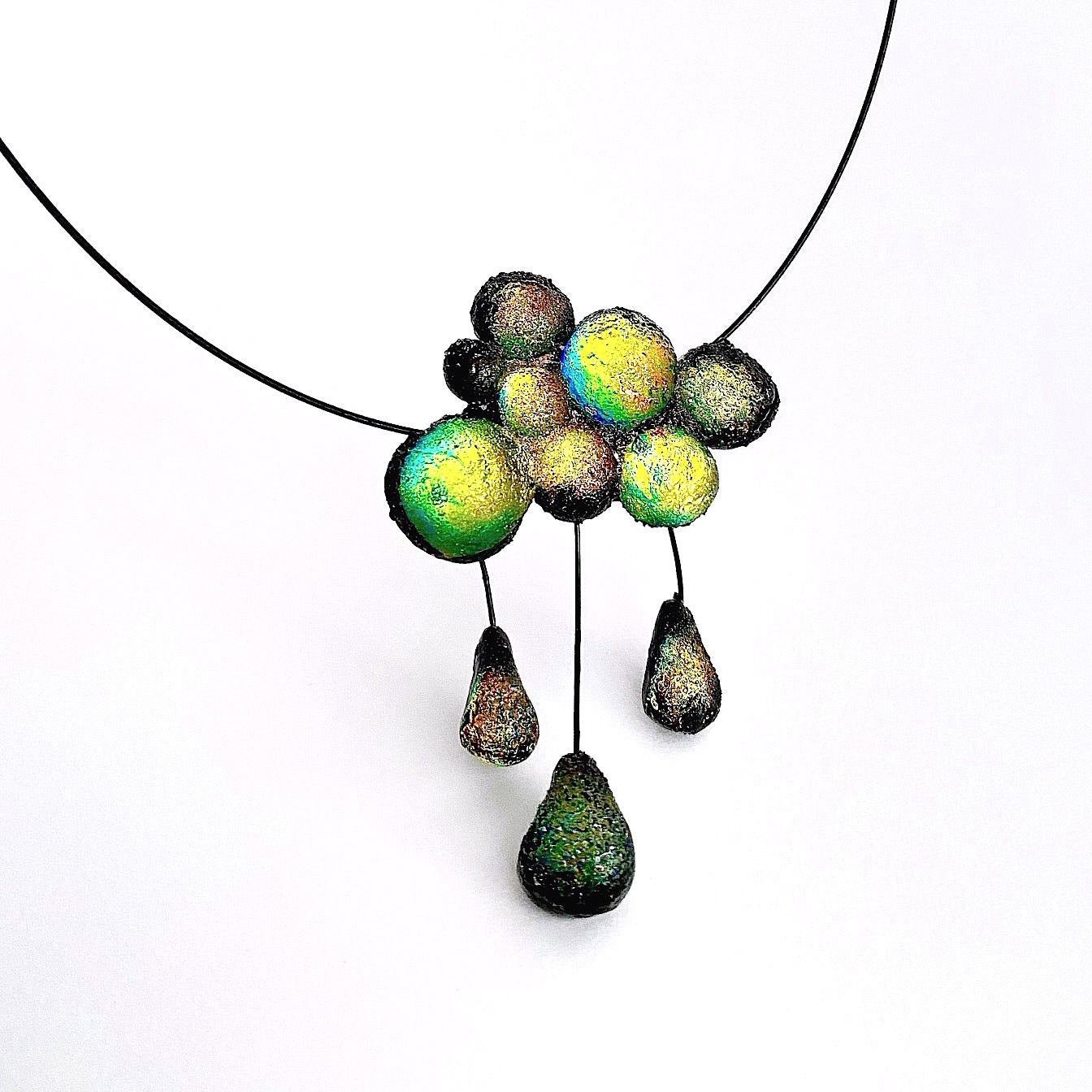 Collier nuage en résine noire irisée vert assemblé sur un câble noir. Fermoir aimant.