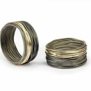 Anneau large composé de fil d'acier inoxydable cerclé. Un fil d'or jaune vient apporté l'éclat et contraste à ce bijou.