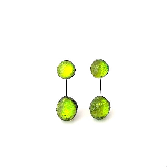 Boucles pendantes vert anis, composées de deux sphères en résine texturée reliées par un câble fin noir et solide. Pour oreilles percées.