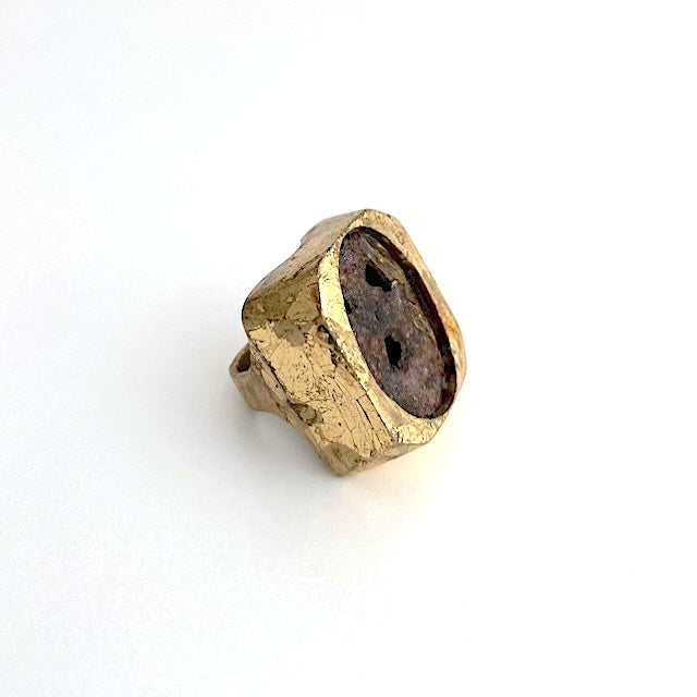 Bague sculpturale rectangulaire en bronze patiné à la feuille d'or avec au centre une plaque ovale de métal usé et rouillé.