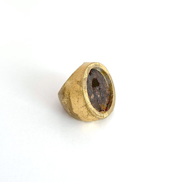 Large chevalière ronde en bronze patiné à la feuille d'or. Au centre une plaque ronde en fer rouillé et usé habille le bijou.