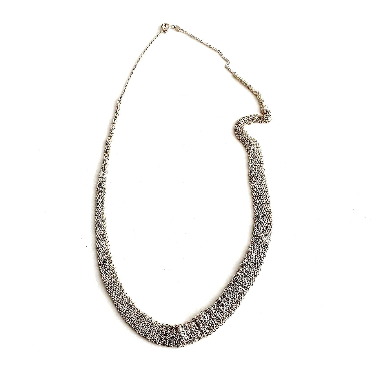 Tour de cou dégradé composé de plusieurs chaînes en argent assemblées les ensemble au fil de soie. Fermoir anneau ressort.