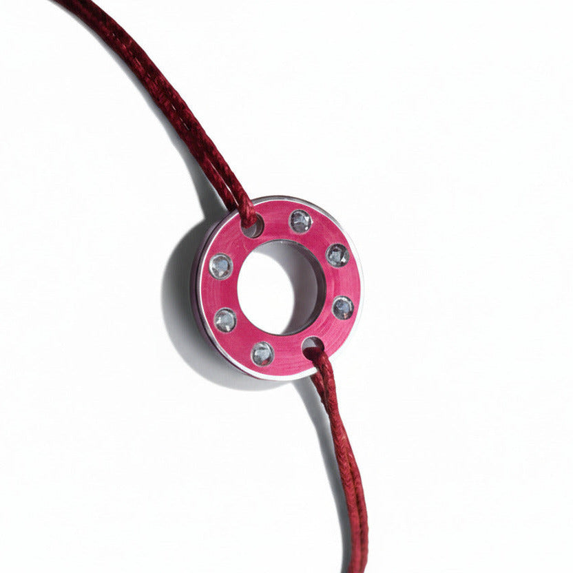 Collection Ready-Made, bracelet upcyclé fait main en rondelle d'aluminium anodisé rouge serti de six aigue-marines. Bijou contemporain et unisexe présenté sur un lien de coton ciré roue.