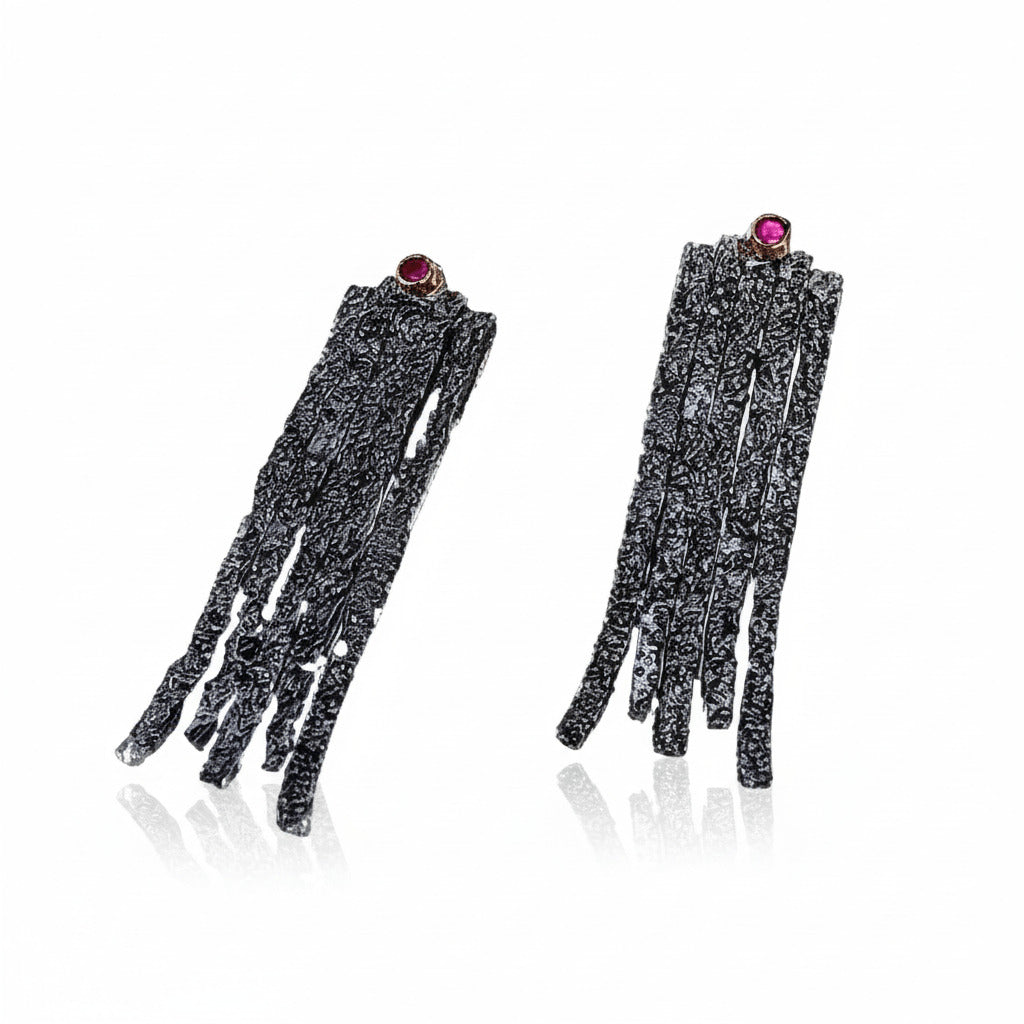 Boucles d'oreilles contemporaines longues de forme rectangulaires en argent patiné, texturé ornées d'un rubis à la base de l'oreille. Un design moderne inspiré de la tradition hellenique séculaire, une pièce organique façonnée à la main par Apostolos Kleitsiotis, artisan joaillier grec.