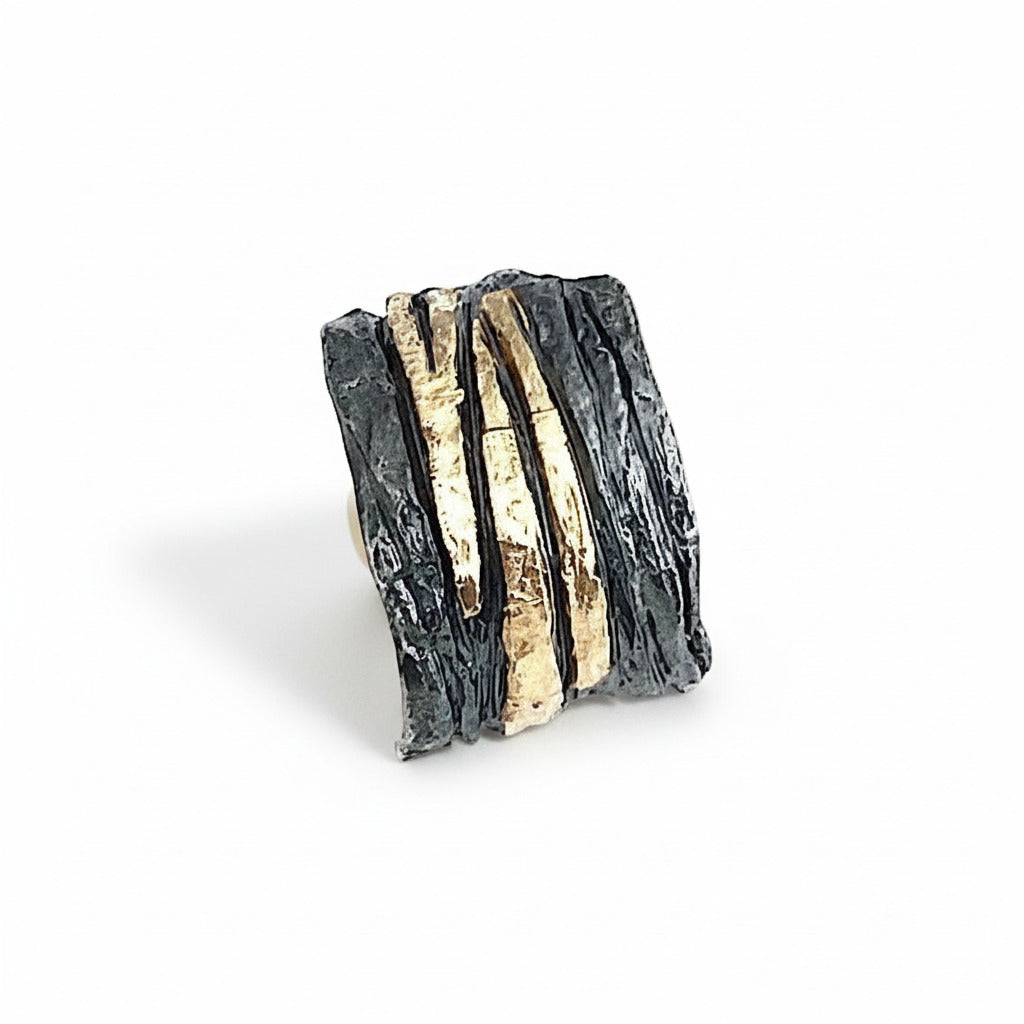 Anneau large et irrégulier en argent patiné et strié, orné de bandes or jaune 18K.