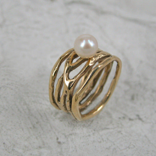 Bague bronze anneaux irréguliers entrelacés, soudés à la base et perle de culture blanche sur le dessus
