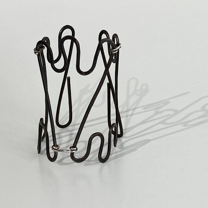 Bracelet manchette ouvert en fer martelé et patiné, ajustée par 3 attaches en argent.