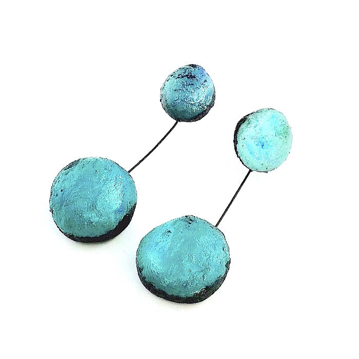 Boucles d'oreilles constituées de 2 sphères en résine irisée bleu lagoon, reliées par un cable noir.