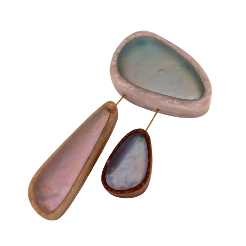 broche composée de 3 éléments de différentes tailles en résine couleurs pastel bleu clair,rose,bleu. les deux petits éléments sont reliés au grand par un cable rigide noir. fermeture aimant. broche posée sur fond blanc