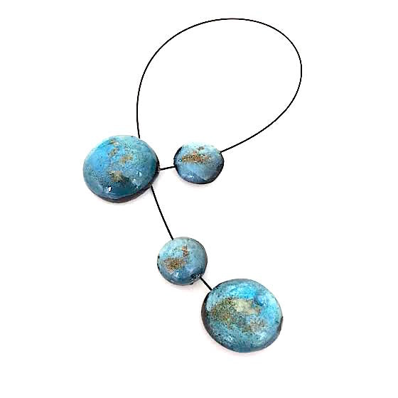Collier 4 éléments ronds en résine irisée bleu clair assemblés sur un cable noir.Fermoir aimanté.