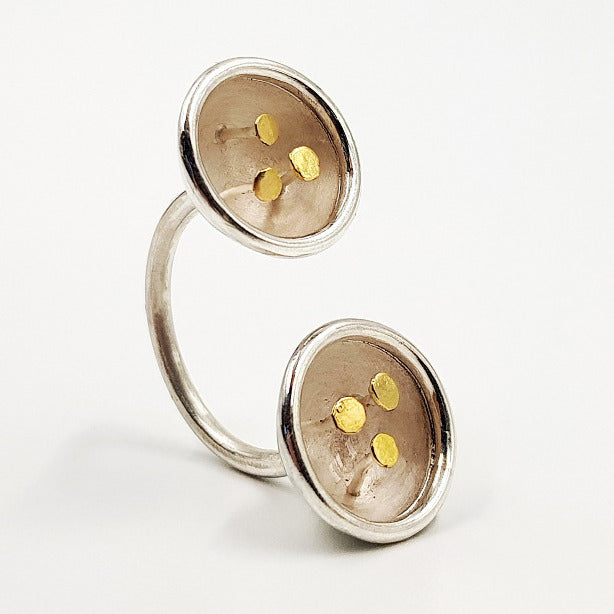 Bague double ouverte composée de 2 coupelles en argent poli et nacre, ornées de 3 petits clous à tête d'or.