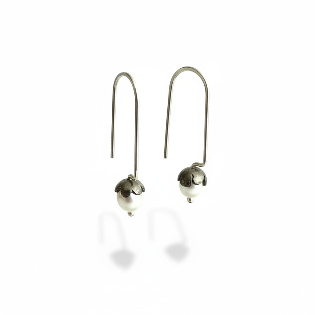 Boucles dormeuses tiges droites en argent forgé et patiné, serties de perles de culture ovales blanches.