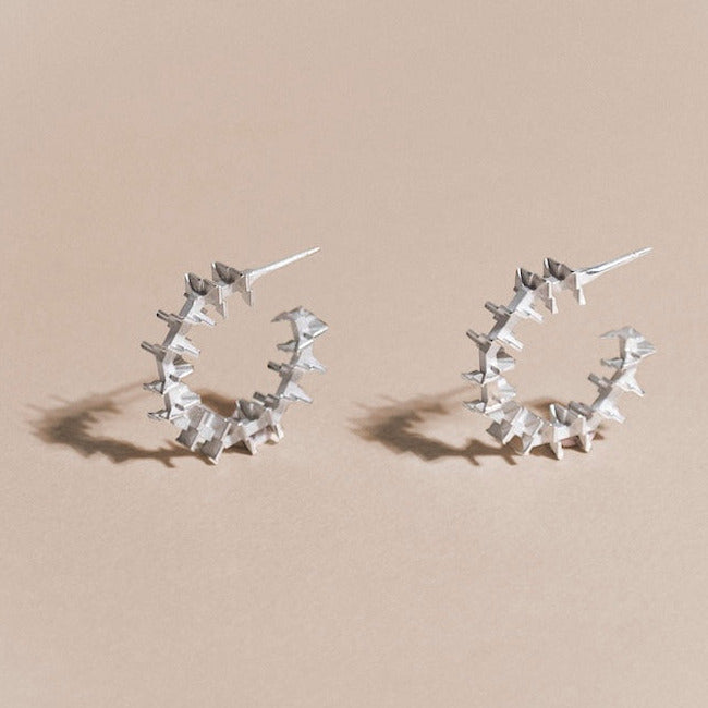 Boucles d'oreilles Cyclo en argent, inspirées des escaliers en colimaçon, détails des finitions satinées et poli. Des créoles à la structure graphique signées Atelier Grandval. 