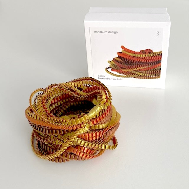 long collier en tissus de satin plissé, aux couleurs marrons, doré, cuivré. Présenté dans sa boîte en carton blanc.