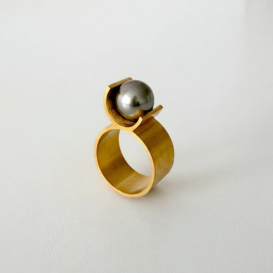 La bague 8 en vermeil se distingue par une architecture minimale : un corps en forme de U vient délicatement soutenir une perle de  Tahiti grise de 9 mm, comme en suspension.
