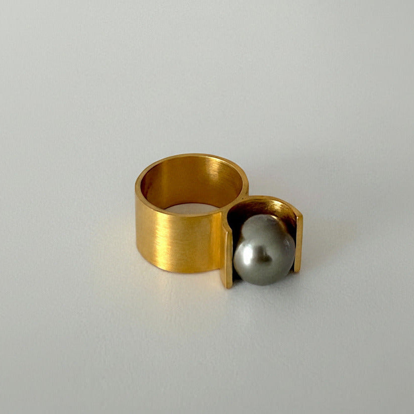 Bijou minimaliste en vermeil avec perle centrale de Tahiti grise. Détail de la bague et du serti en forme de U.