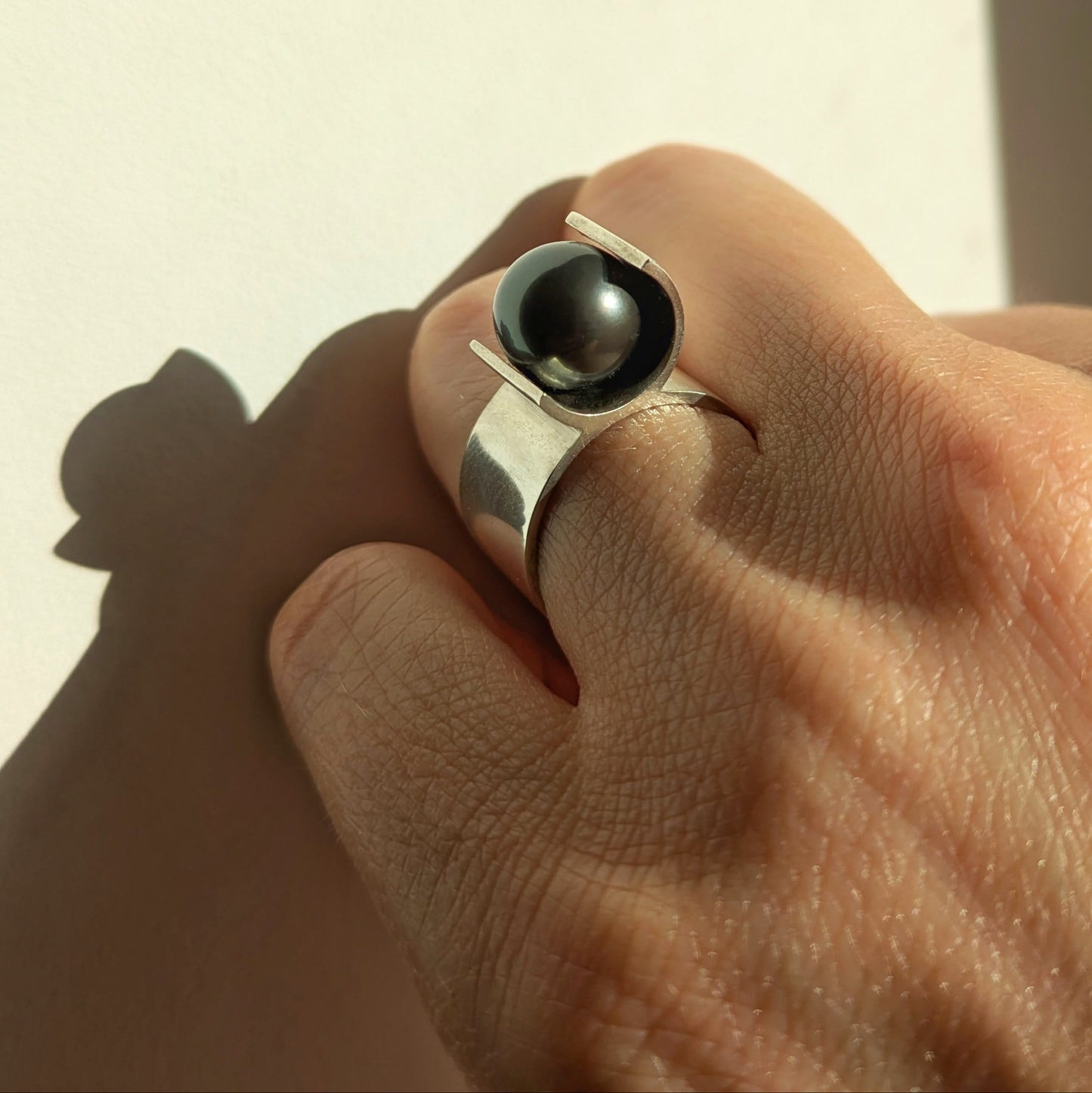 Bague architecturale en argent mettant en valeur une perle de Tahiti noire. Bijou porté.