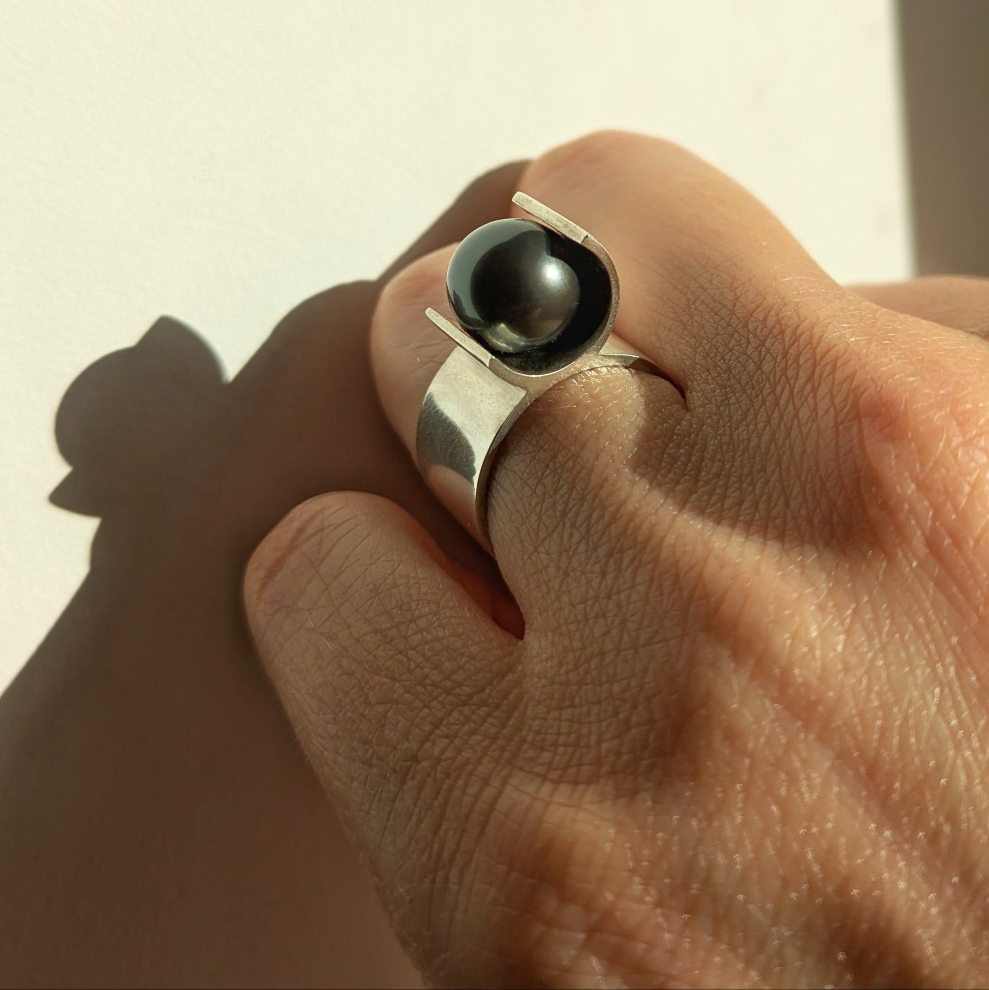 Bague architecturale en argent mettant en valeur une perle de Tahiti noire. Bijou porté.