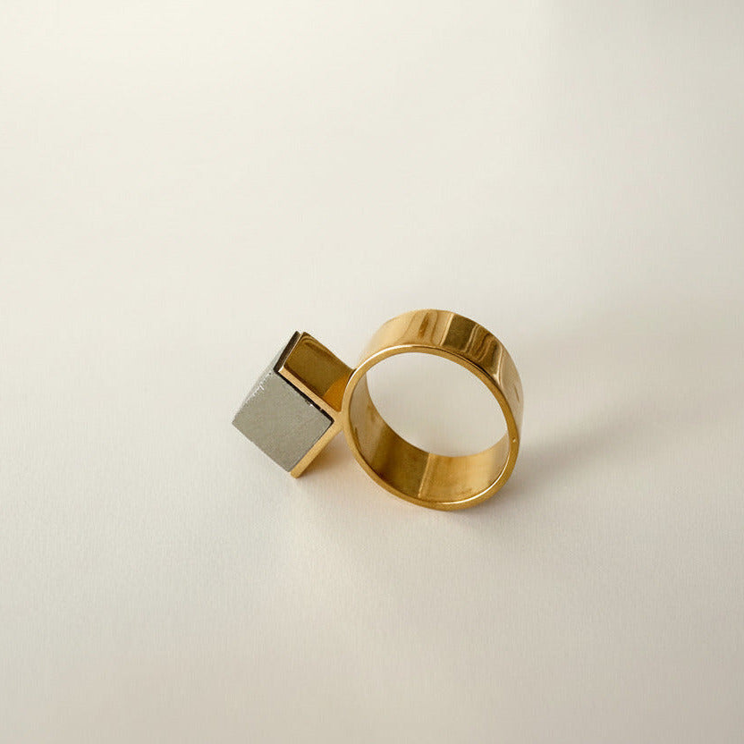Bijou minimaliste en vermeil mettant en valeur un cube de pyrite dans un serti triangulaire. Bague de profil.