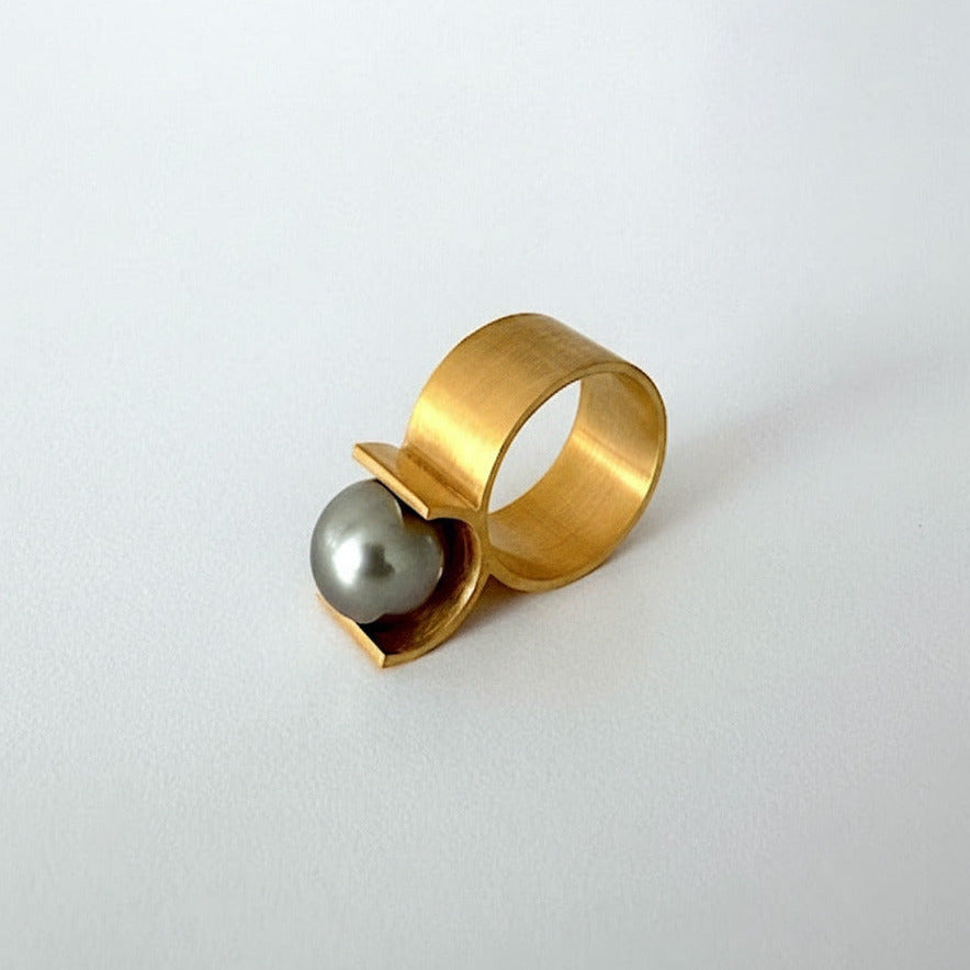Une bague contemporaine en vermeil avec un corps  de bague en forme de U qui vient sertir et soutenir une perle grise de Tahiti de 9 mm.