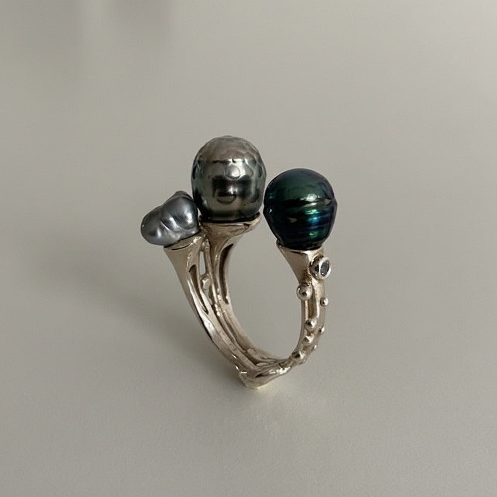Bague ouverte présentant deux perles de Tahiti  sculptée,de couleurs différentes et une perle keshi carrée.L'anneau en argent est orné de petites pierres de couleurs. Une pièce réalisée à la main par Ivan Michelson.