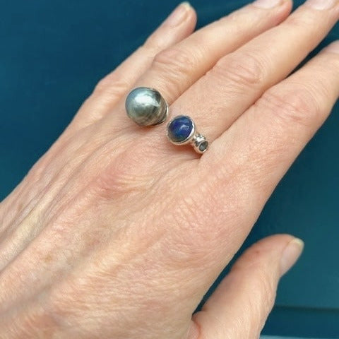 Bague "Toi et Moi" en argent avec d'un côté, une perle de Tahiti sculptée et de l'autre une opale bleue en cabochon et aigue-marine.
