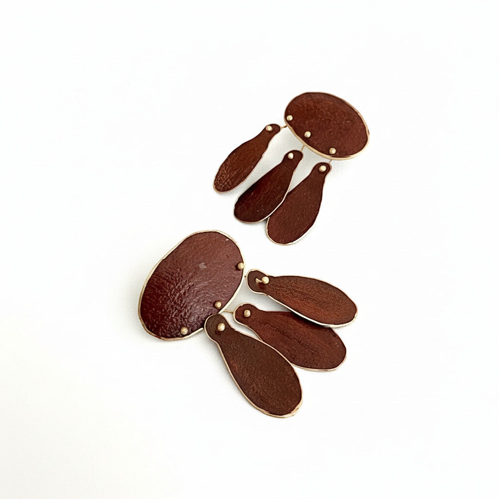 Boucles d’oreilles Héritage en bronze laminé peint à la main avec des pigments acrylique bordeaux. Un ovale et trois pampilles pour une élégance moderne inspirée des bijoux du XVIIIe siècle.