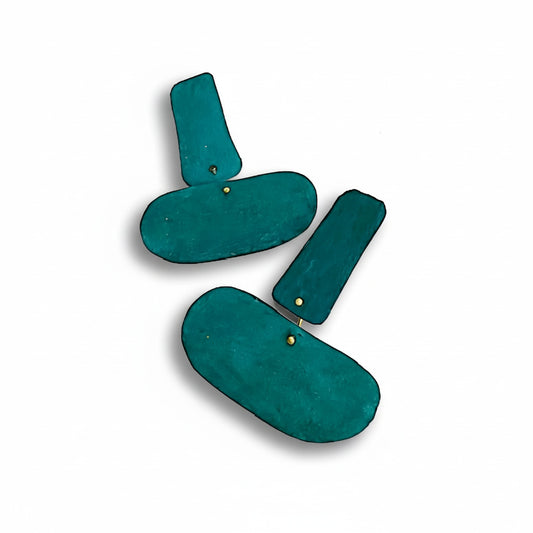 Boucles XL associent deux formes géométriques reliées, offrant une ligne fluide et contemporaine. Façonnées en bronze laminé et peintes à la main en bleu canard.