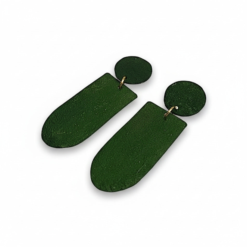 Ces boucles pendantes vert foncé, aux formes géométriques sont réalisées en bronze peint à la main avec des pigments acryliques. Elles sont légères et confortables à porter au quotidien.