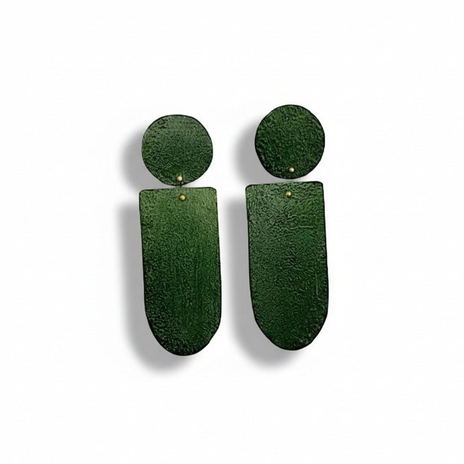 Ces boucles pendantes vert foncé, aux formes géométriques sont réalisées en bronze peint à la main avec des pigments acryliques. Elles sont légères et confortables à porter au quotidien. Création artisanale de l'artiste grecque Dora Haralambaki.