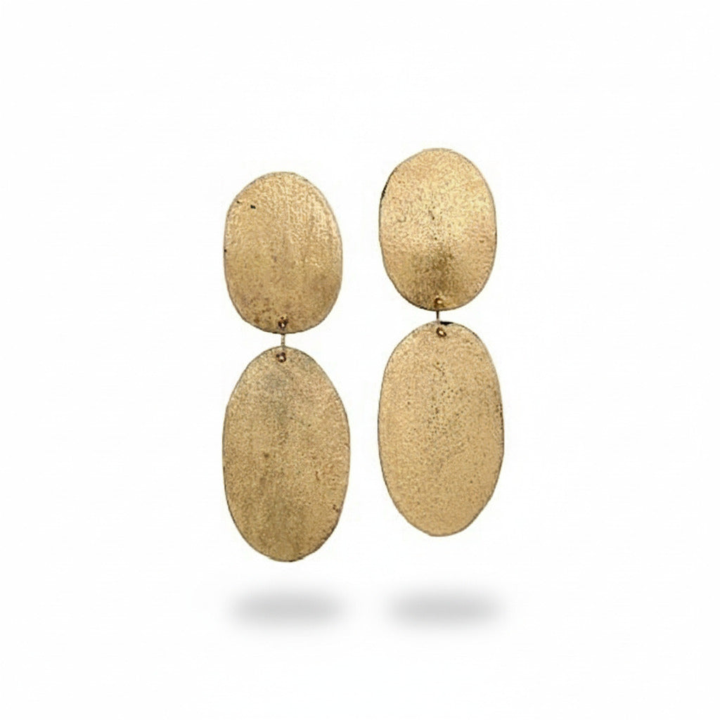 Boucles XL en bronze beige texturé, peintes à la main. Deux ovales reliés pour un bijou léger, géométrique et inspiré de l’art contemporain.