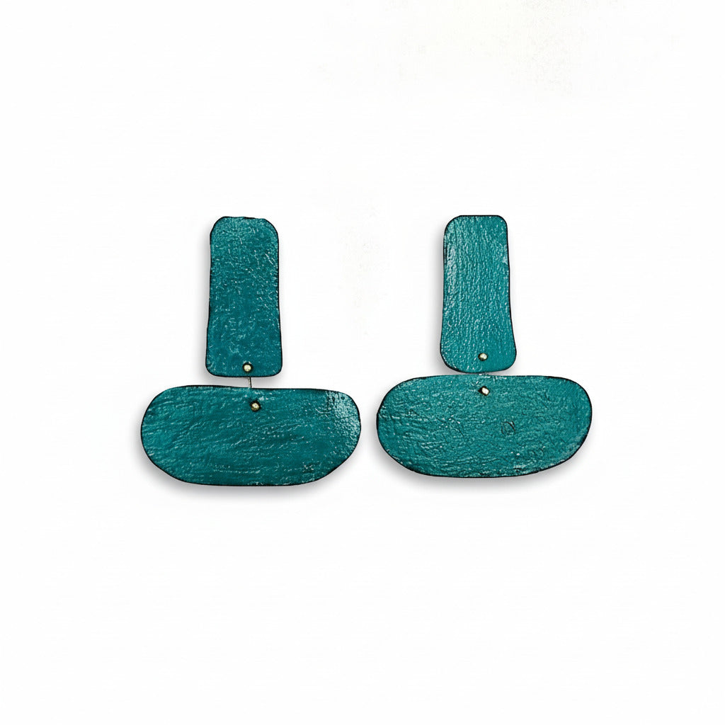 Boucles XL associent deux formes géométriques reliées, offrant une ligne fluide et contemporaine. Façonnées en bronze laminé et peintes à la main en bleu canard. Une création artisanale Dora Haralambaki, atiste grecque.