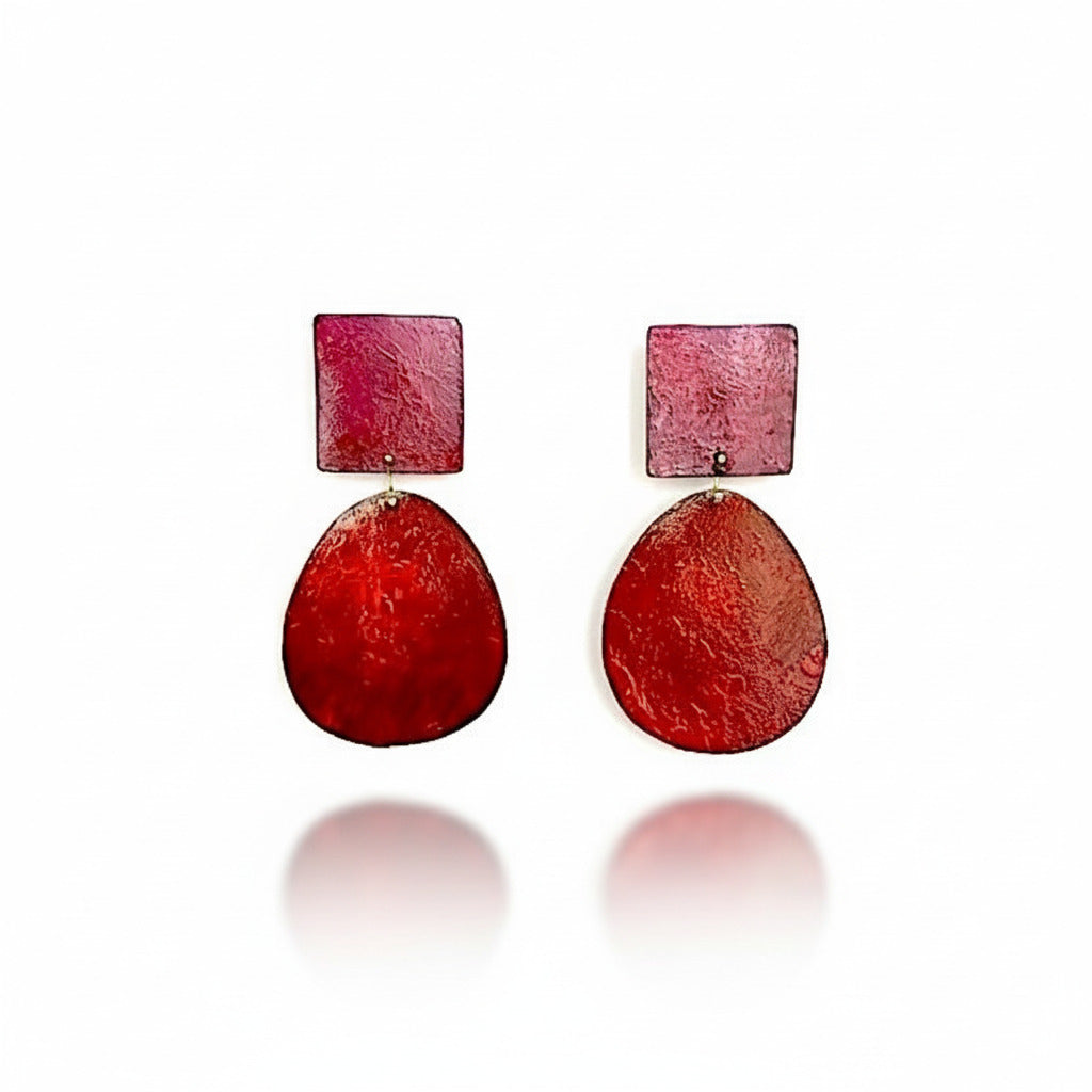 ces boucles XL associent un ovale brun orangé à un carré fuchsia. En bronze laminé peint à la main. 