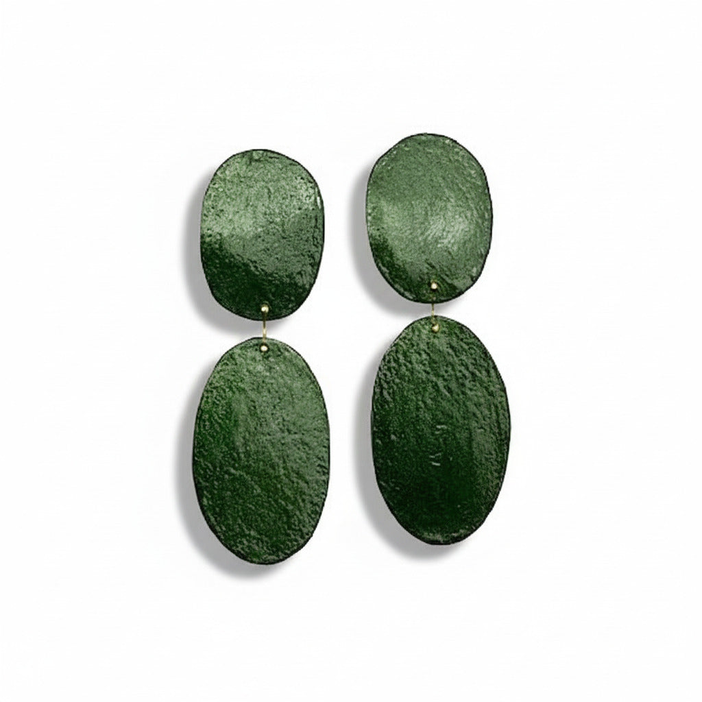 Boucles XL en bronze vert texturé, peintes à la main. Deux ovales reliés pour un bijou léger, géométrique et inspiré de l’art contemporain.