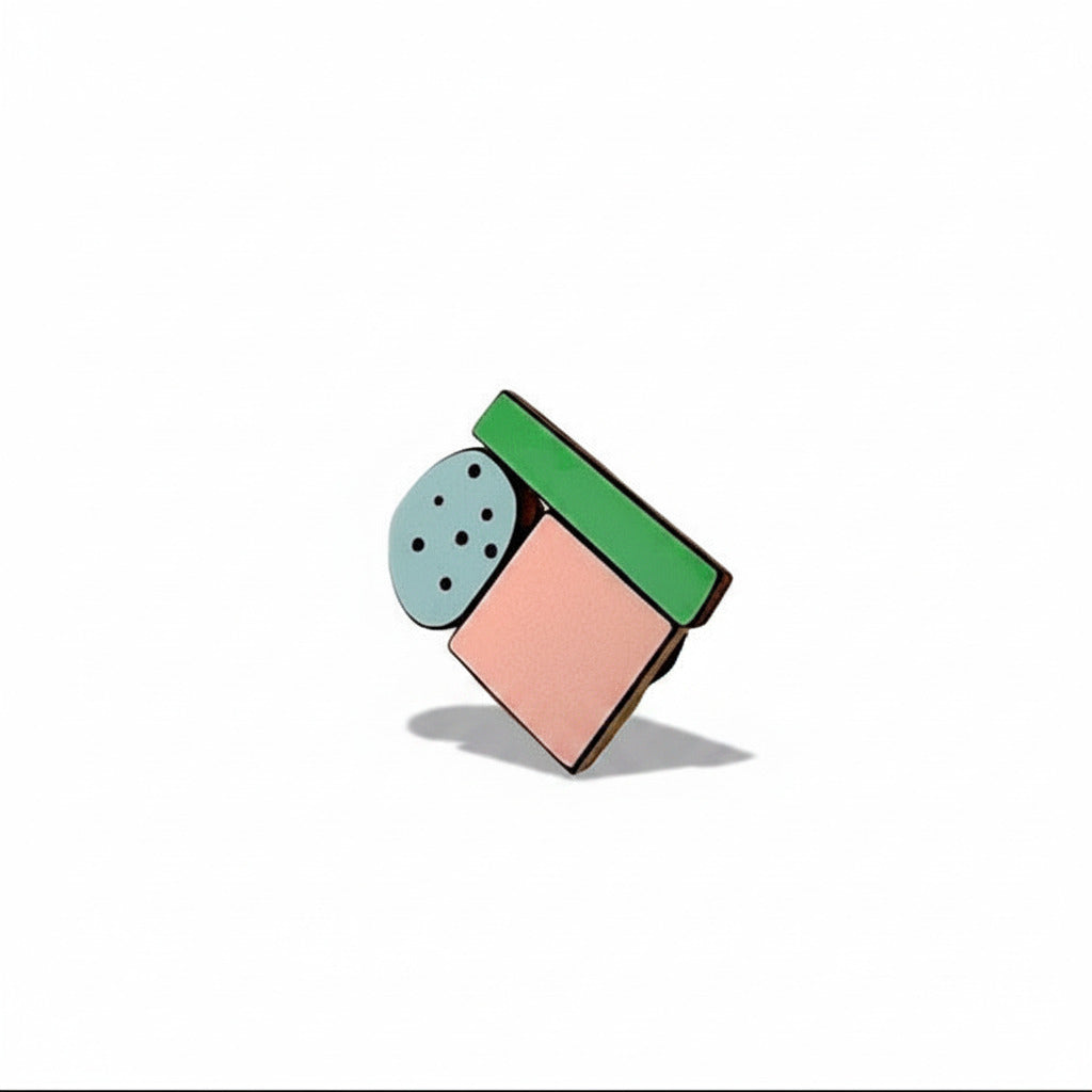 Mini broche artisanale modulable en bois et Formica composée de trois éléments : un rond gris un carré rose poudré et un rectangle vert.