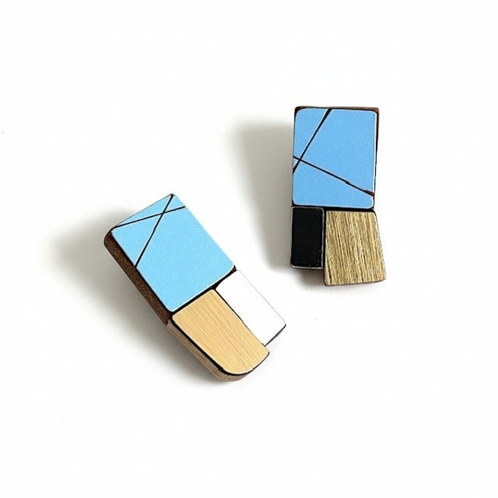 Boucles d’oreilles géométriques de forme rectangulaire en bois et formica bleu clair, gris, et doré métallisé texturé. Une création artisanal de l'artiste belge Karen Vanmol.