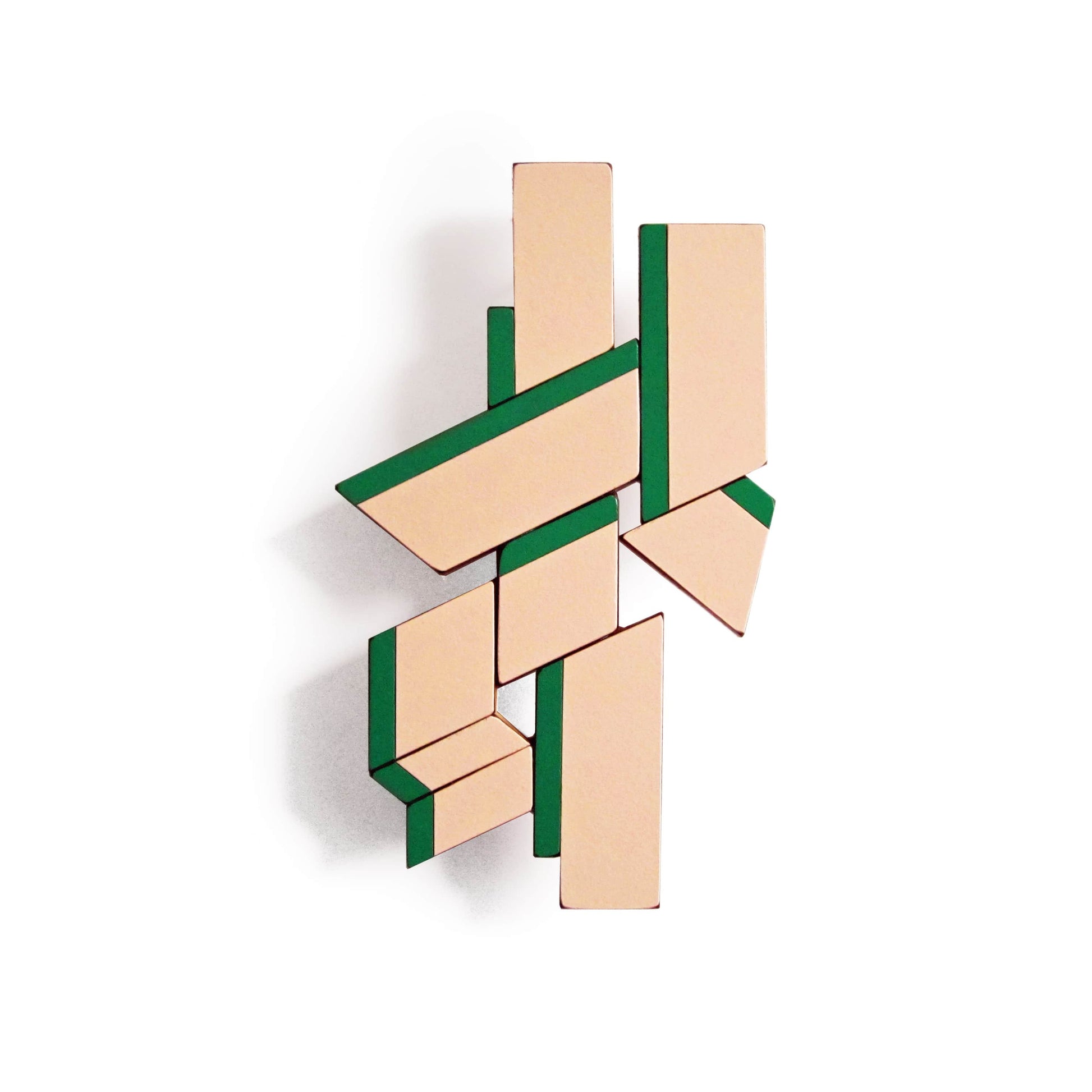 Broche XL en bois et formica rose soulignée de bandes vertes, jouant sur les lignes et la perspective. Créée à la main par l’artiste belge Karen Vanmol.