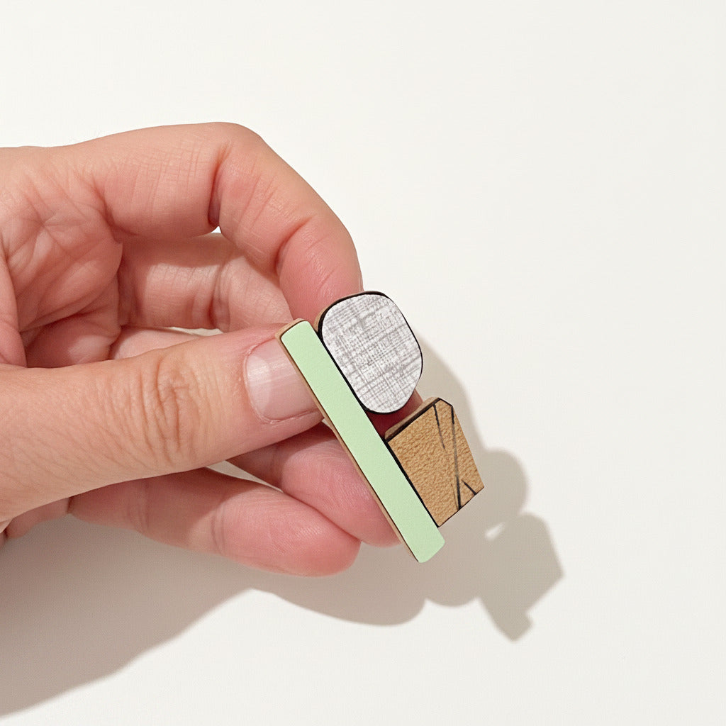 Détail broche contemporaine colorée en bois avec design graphique  et formica strié. 
