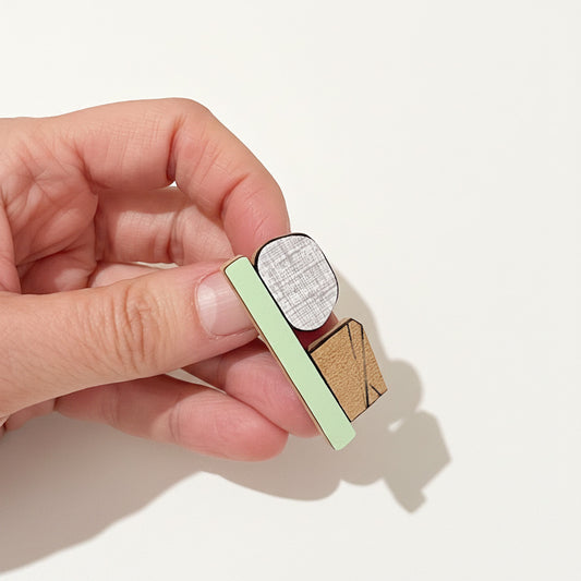 Détail broche contemporaine colorée en bois avec design graphique  et formica strié. 