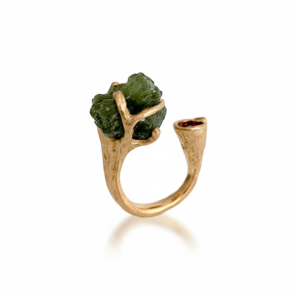 Cette bague ouverte aux formes organiques en bronze accueille d'un côté une tourmaline brute et sculpturale et de l'autre côté une petite tourmaline rose.