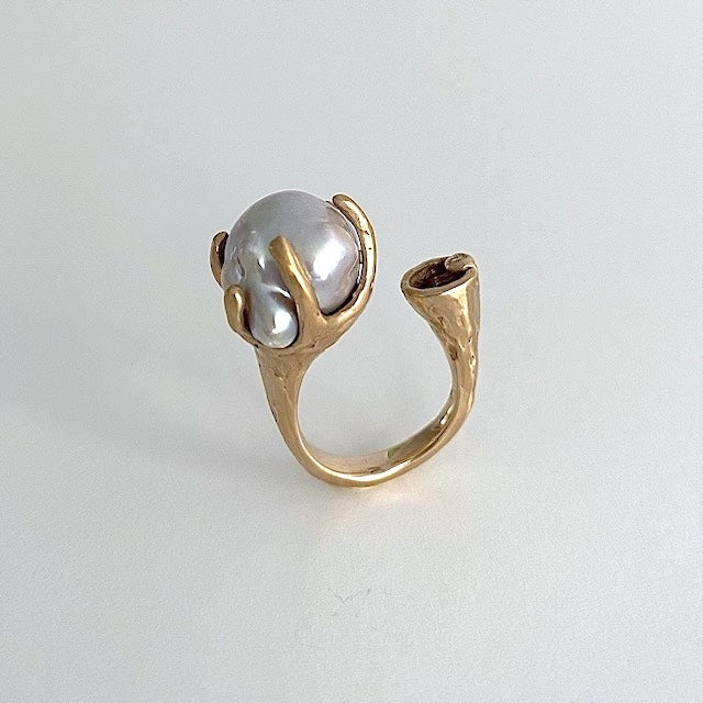 Bague forme "Toi et Moi" en bronze ornée d'une perle grise baroque sertie par six griffes et d'un diamant taille brilliant.