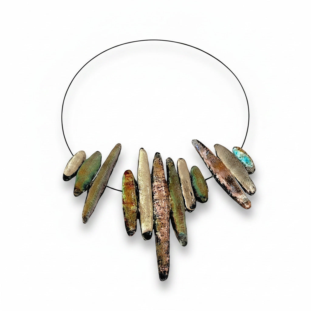 Collier composé de douze Stalactites de différentes tailles en résine irisée beige rosé et vert sur câble noir. Fermoir aimanté intégré dans deux éléments.