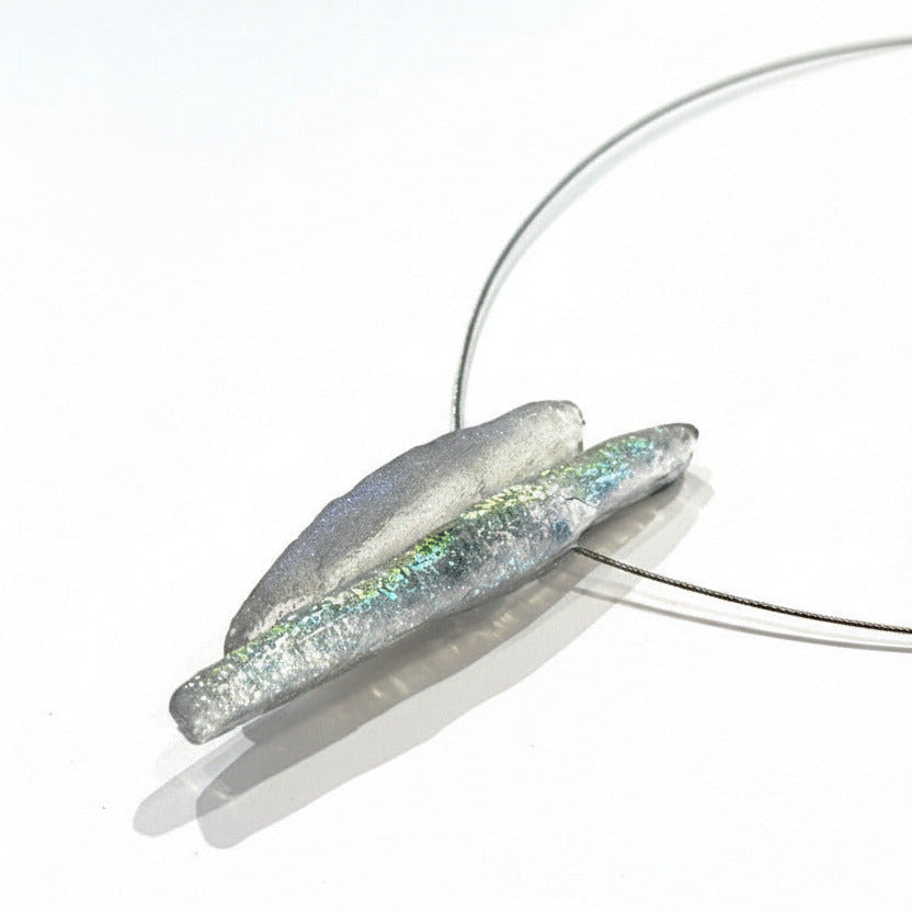 Collier minimaliste,inspiration minérale composé de deux éléments allongés en forme de stalactite. Fabrication artisanale en résine texturé opalescente grise.