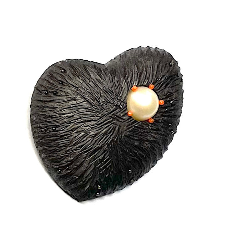 Broche artisanale en ébène sculpté et gravé avec perle de culture blanche ornée de cinq mini perles en nylon rouge.