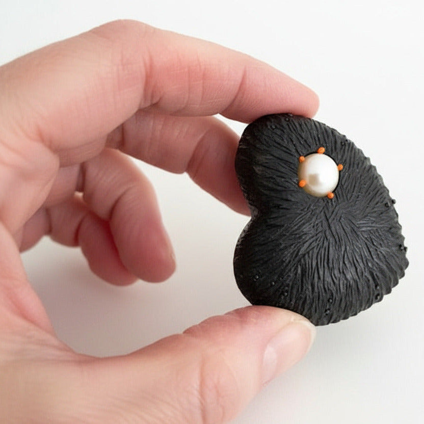 Broche cœur noir en ébène sculpté ornée d'une perle de culture blanche. bijou unique fait main à Paris par la créatrice Marie Pierre Ginestet.