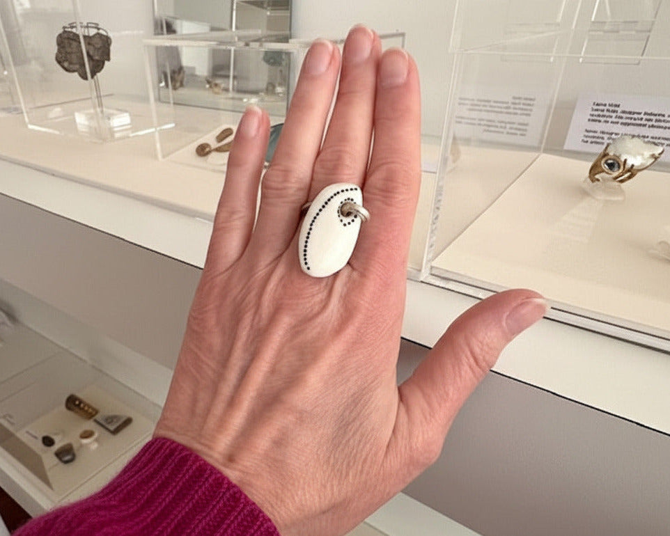 Bague pampille en os tatoué et argent texturé. Détail, bijou porté.