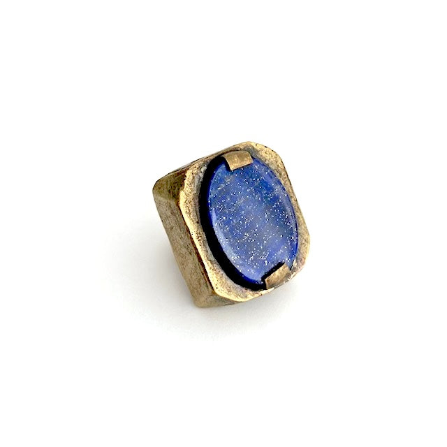 Bague rectangulaire en bronze au centre un lapis-lazuli taillé ovale est serti par deux griffes de chaque côté. 