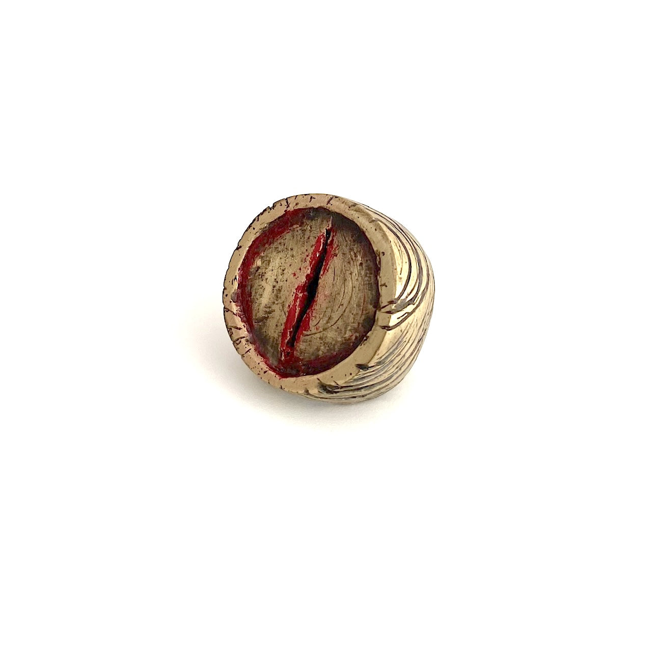 Bague sculpturale ronde en bronze , une entaillé au centre dans le métal est soulignée de peinture acrylique rouge.  Les flancs la bague sont griffés de noir.