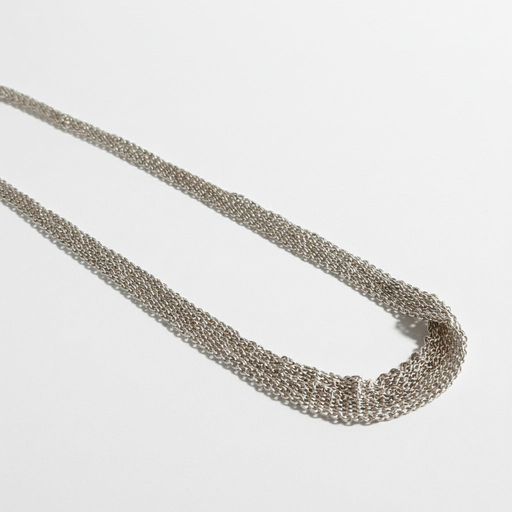 Tour de cou dégradé composé de plusieurs chaînes en argent assemblées  ensemble au fil de soie. Un collier délicat fait entièrement à la main par l'artiste belge Ria Lins.